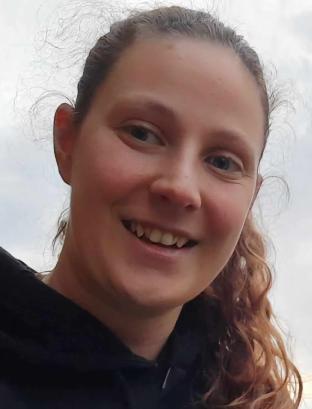 Gezicht van lachend meisje met krullend haar in een staart