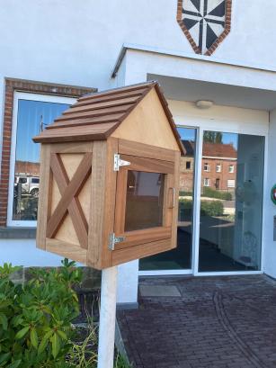 boekenruilkastje in hout aan een gebouw