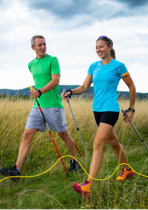 Man en vrouw die in de velden aan Nordic Walking doen