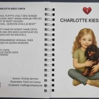 een meisje met blond haar met een zwarte cavalier king charles op haar schoot